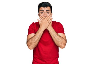 Günlük kırmızı tişört giyen İspanyol sakallı bir adam yanlışlıkla ağzı ellerle kapatarak şok etti. gizli kavram. 