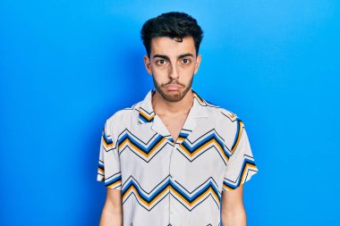 Günlük giysiler giyen genç İspanyol bir adam depresyonda ve sıkıntıdan endişe ediyor, kızgın ve korkmuş bir şekilde ağlıyor. hüzünlü ifade. 