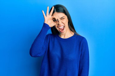 Gündelik giysiler giyen genç İspanyol kadın gülümsüyor. Mutluluktan gülümsüyor. 