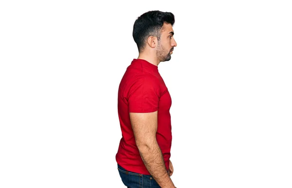 髭を生やしたヒスパニック系の男は サイドを見てカジュアルな赤いTシャツを着て 自信を持って笑顔で自然な顔でプロファイルのポーズをリラックス — ストック写真
