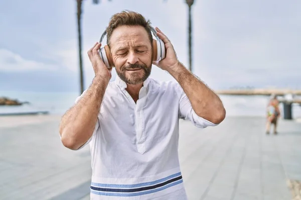 海のそばで音楽を聴く中年の男 — ストック写真