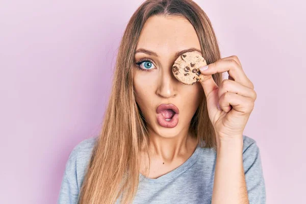 Young Blonde Girl Holding Cookie Eye Scared Amazed Open Mouth — Stock Photo, Image