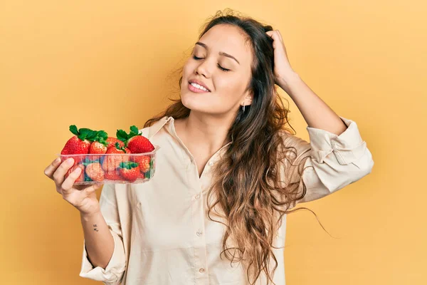 Joven Chica Hispana Sosteniendo Fresas Sonriendo Confiado Tocando Pelo Con —  Fotos de Stock