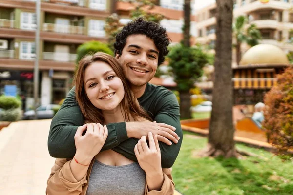 Young interracial couple smiling happy and hugging standing at the city.