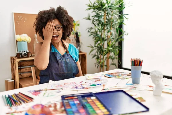 在艺术工作室用一只手捂住一只眼睛 脸上带着自信的微笑 有着令人惊讶的情绪的美丽的非洲裔美国女人 — 图库照片