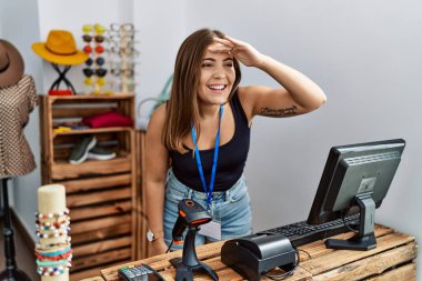Genç esmer kadın perakende dükkanında açık mesajla afiş tutuyor. Çok mutlu ve gülümsüyor. Başını kaldırıp uzaklara bakıyor. arama kavramı. 