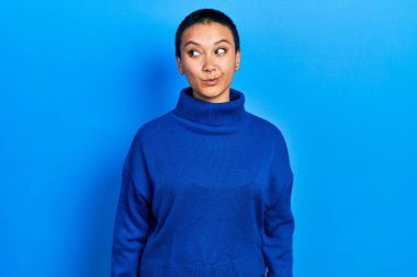 Kısa saçlı, balıkçı yaka kazak giyen, gülümseyen ve kafasını çeviren güzel İspanyol kadın.. 