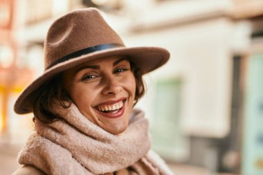 Şık giyinen genç İspanyol kadın şehirde dikiliyor..