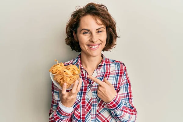 Jovem Morena Segurando Tigela Com Macarrão Italiano Sorrindo Feliz Apontando — Fotografia de Stock