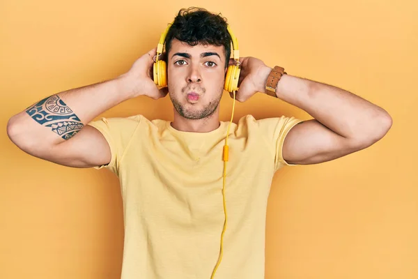 Joven Hispano Escuchando Música Usando Auriculares Hinchando Mejillas Con Cara — Foto de Stock