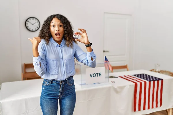 投票によって政治運動に立っている美しいヒスパニック系の女性は 反対側に手指で指して驚いて 口を開けて驚くような表現 — ストック写真