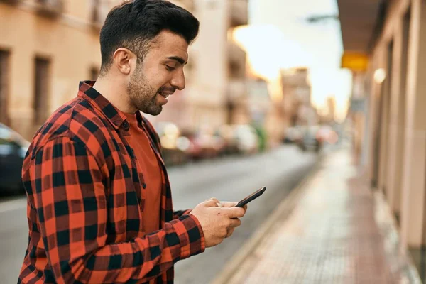 Jonge Spaanse Man Glimlacht Gelukkig Met Behulp Van Smartphone Stad — Stockfoto