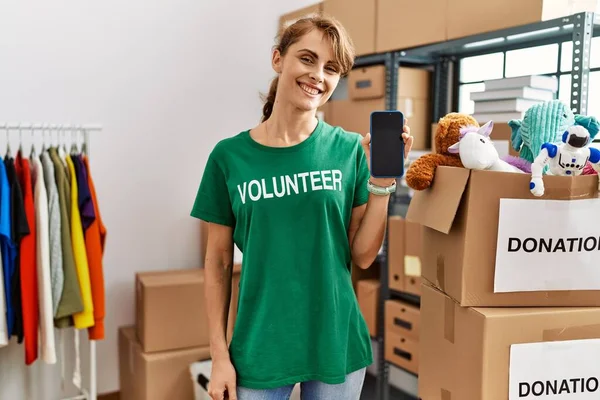 Jovem Mulher Voluntária Caucasiana Sorrindo Feliz Mostrando Aplicativo Voluntariado Centro — Fotografia de Stock