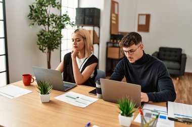Ofiste çalışan ciddi ifadeli iki iş adamı..