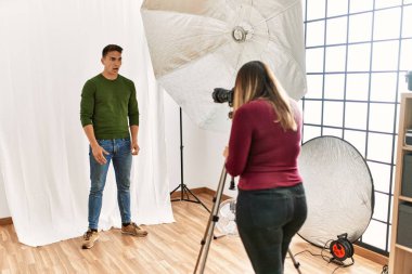 Young man at photography studio scared and amazed with open mouth for surprise, disbelief face 