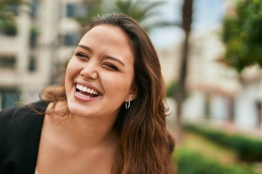 Genç İspanyol kadın gülümseyerek şehirde mutlu mesut dikiliyor..