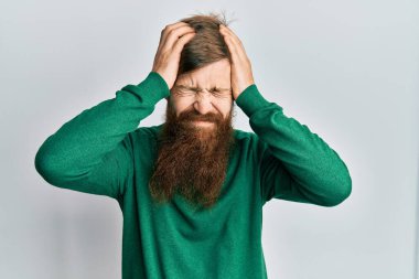 Uzun sakallı, günlük kıyafetler giyen, baş ağrısı çeken, çaresiz ve stresli bir adam. Çünkü acı ve migren ağrısı var. Eller başının üstünde.. 