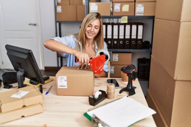 Genç sarışın kadın ecommerce iş işçisi ofiste paket paketleme