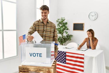 Genç Amerikalı seçmen seçim kurulunda oy sandığına koyuyor..