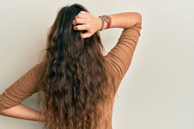 Gündelik giysiler ve gözlükler giyen genç İspanyol kız, elleri kafasında şüpheyi geriye doğru düşünüyor. 