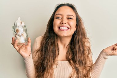 Genç İspanyol kız elinde bir bardak sarımsak tutarak gururla haykırıyor, zaferi ve başarıyı kutluyor. 