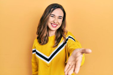 Gündelik kıyafetler giyen, neşeli gülümseyen, yardım eli uzatan ve kabul gören genç İspanyol kız.. 