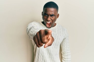 Genç, Afro-Amerikan bir adam, gündelik giysiler içinde kameraya kızgın ve hayal kırıklığına uğramış bir şekilde bakıyor. 