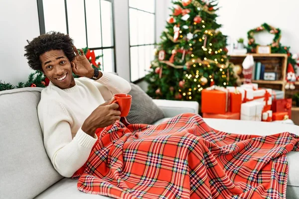 Joven Afroamericano Sentado Sofá Bebiendo Café Junto Árbol Navidad Sonriendo — Foto de Stock