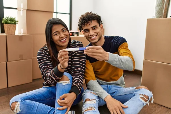 Young Latin Couple Smiling Happy Holding Pregnancy Test Sitting Floor — Stock Photo, Image