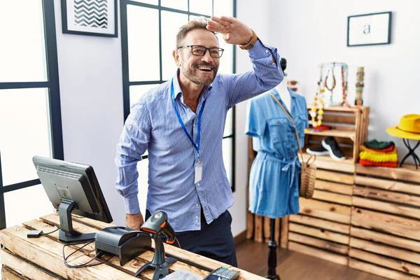 Orta yaşlı bir adam perakende mağazasında yönetici olarak çalışıyor. Çok mutlu ve gülümsüyor. Çok uzaklara bakıyor. arama kavramı. 