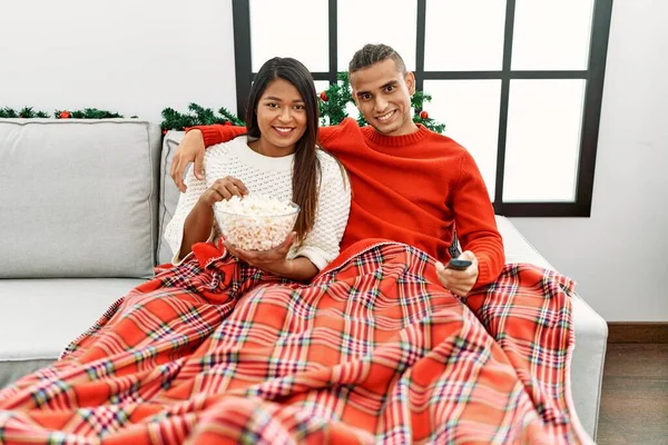 Young Latin Couple Watching Movie Sitting Sofa Home — Zdjęcie stockowe