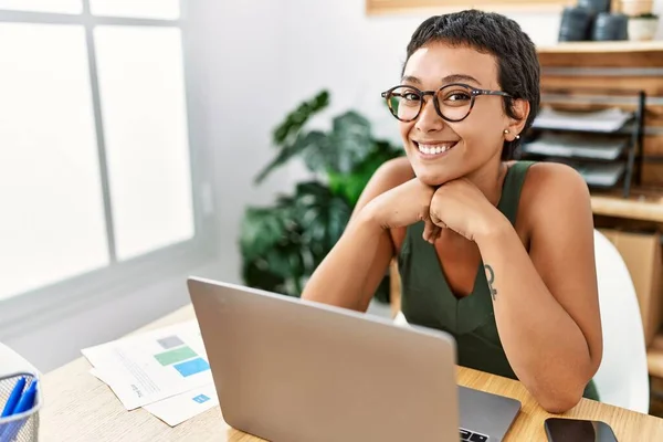 年轻的惊慌失措的女人带着自信的笑容使用笔记本电脑在办公室工作 — 图库照片