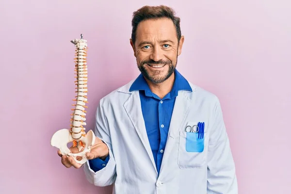 Médico Mediana Edad Hombre Sosteniendo Modelo Anatómico Columna Vertebral Mirando — Foto de Stock