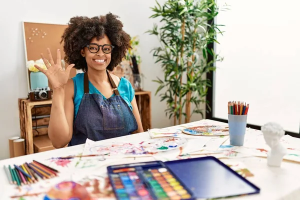 美丽的非洲裔美国女人 在艺术工作室里画着非洲的头发 带着自信和快乐的微笑 用手指指指着五号 — 图库照片