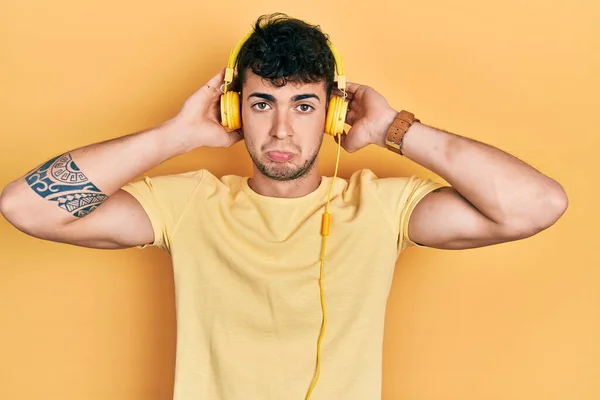 Young Hispanic Man Listening Music Using Headphones Depressed Worry Distress — Stock Photo, Image