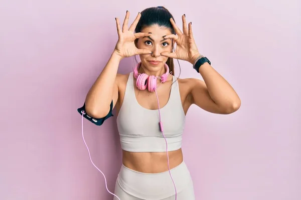 Young Hispanic Woman Wearing Gym Clothes Using Headphones Trying Open — 스톡 사진