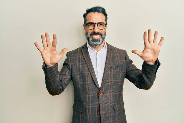 Middle age man with beard and grey hair wearing business jacket and glasses showing and pointing up with fingers number ten while smiling confident and happy.
