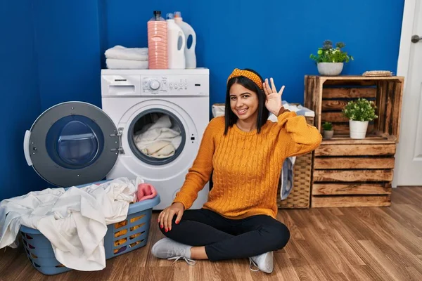 Çamaşır yıkayan, ağzı kulaklarına varan bir gülümsemeyle dedikoduları ya da dedikoduları dinleyen genç İspanyol kadın. Sağırlık kavramı. 