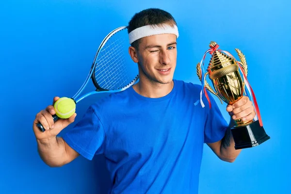 Young Caucasian Man Playing Tennis Holding Trophy Winking Looking Camera — Stockfoto