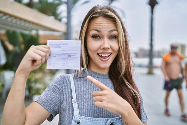 Young Caucasian Woman Holding Covid Record Card Smiling Happy Pointing — Fotografia de Stock