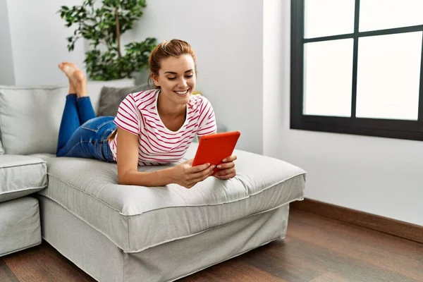 Jovem Usando Touchpad Deitado Sofá Casa — Fotografia de Stock