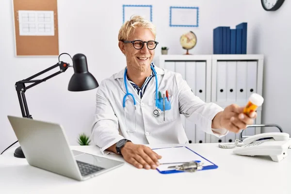 Joven Hombre Caucásico Vistiendo Uniforme Médico Sosteniendo Pastillas Clínica — Foto de Stock