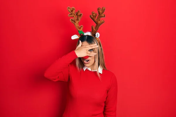 Beautiful Hispanic Woman Wearing Deer Christmas Hat Red Nose Peeking — Stockfoto