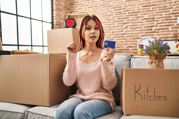 Kafkasyalı genç bir kadın elinde yeni bir kredi kartı olan bir eve taşınıyor. Bir fikir ya da soru işareti ile şaşırmış bir şekilde mutlu bir yüzle işaret ediyor. 