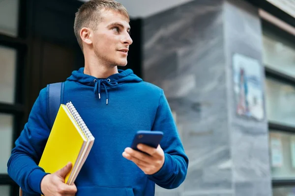 Młoda Blondynka Korzystająca Smartfona Trzymającego Notatnik Uniwersytecie — Zdjęcie stockowe