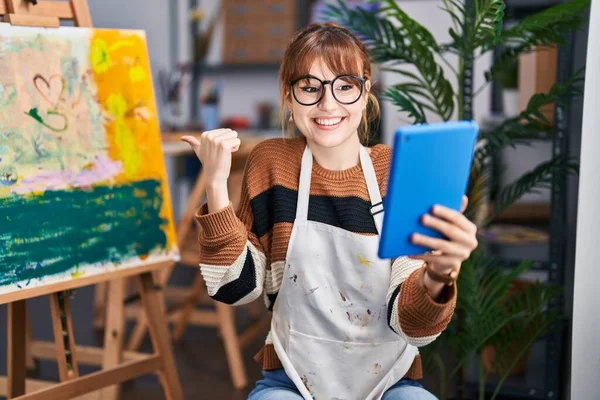 年轻美丽的女艺术家用平板电脑把手指指向侧面 一边做视频通话一边笑着高兴地张开嘴 — 图库照片