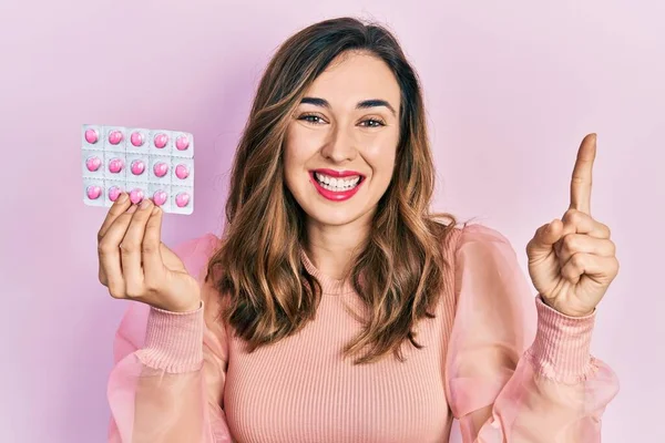 Elinde haplarla gülümseyen genç İspanyol kız bir fikir ya da soruyla mutlu bir yüzle işaret ediyor. 