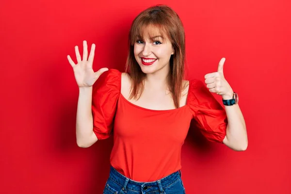 Kırmızı Tişörtlü Kızıl Saçlı Genç Bir Kadın Altı Numaralı Parmaklarıyla — Stok fotoğraf