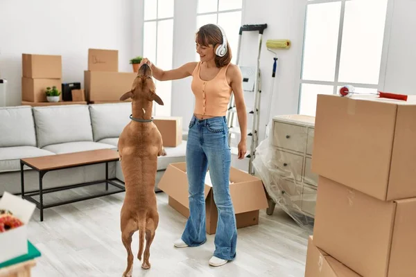 Joven Mujer Caucásica Escuchando Música Alimentación Perro Casa —  Fotos de Stock