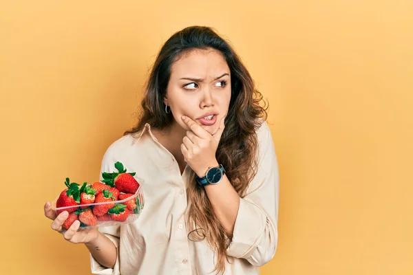 Ung Latinamerikansk Flicka Håller Jordgubbar Tänker Orolig För Fråga Orolig — Stockfoto